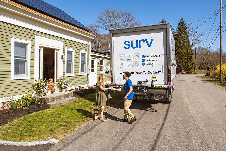 two people in a handshake and a moving truck