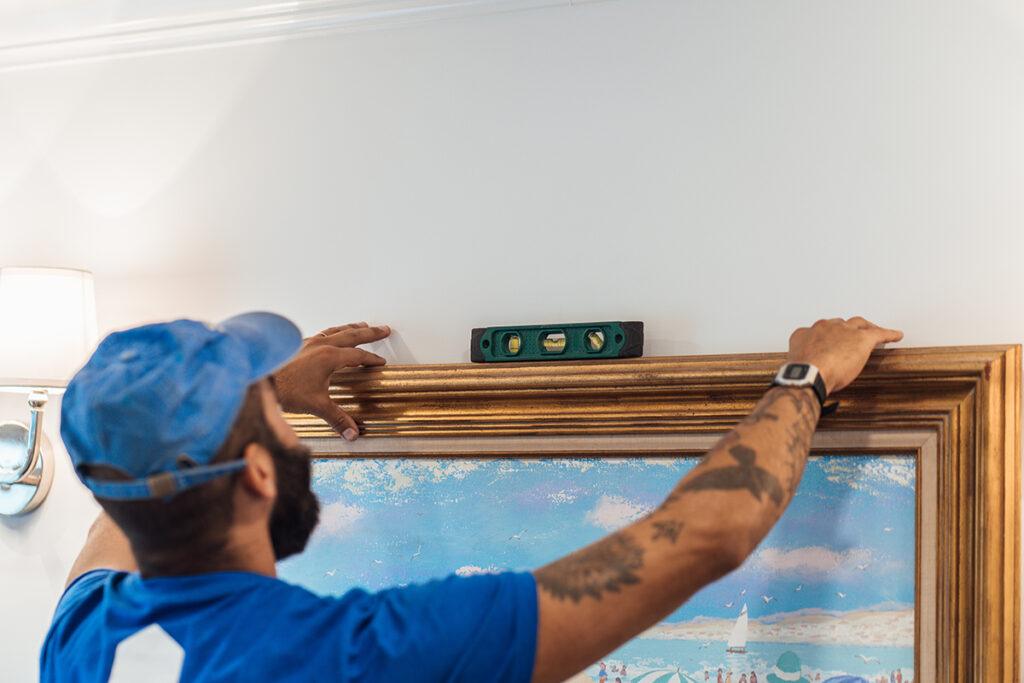 Surv worker hanging a photo 2
