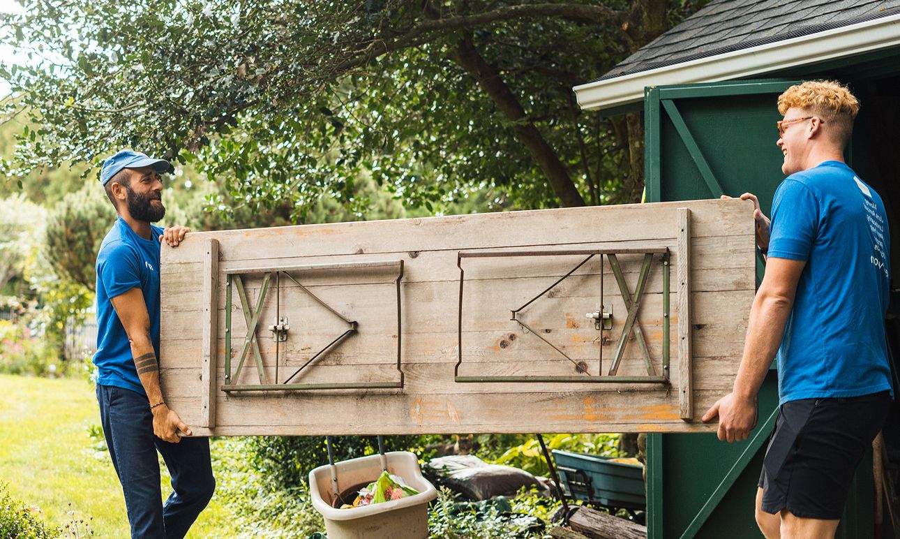 Two Surv workers carrying a table