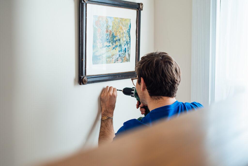 Surv worker hanging a photo