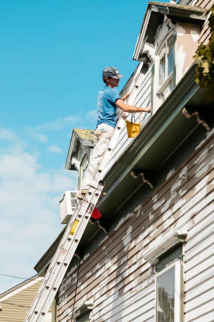 Surv worker painting a house