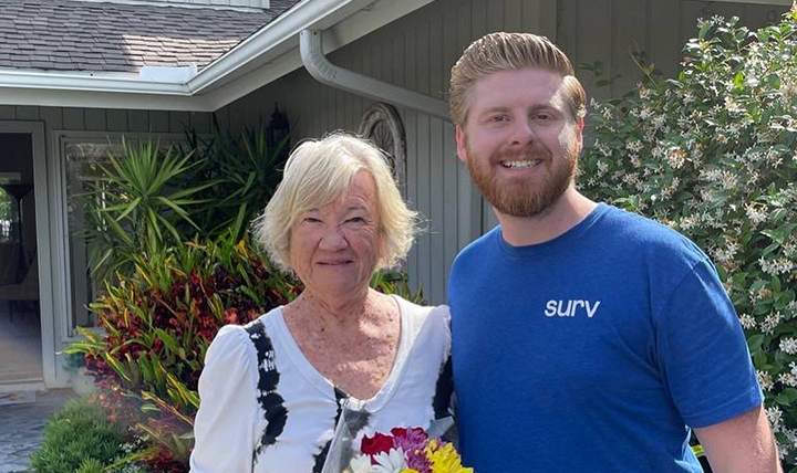 A Surv employee posing with an elderly woman