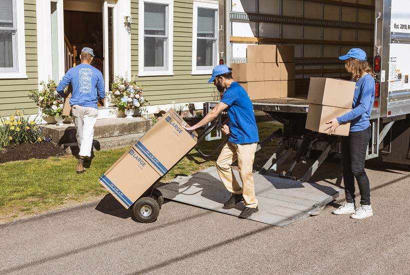 A crew unloading moving boxes from a truck