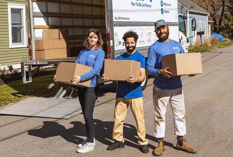 A crew holding moving boxes