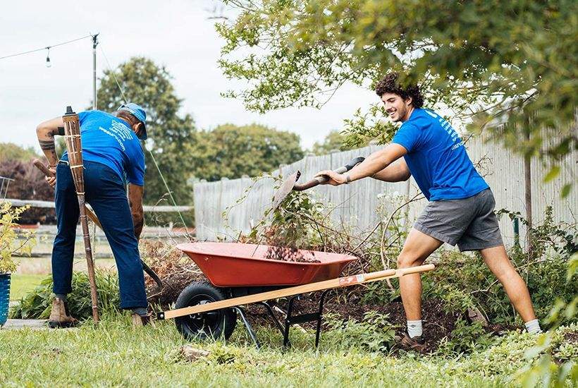 Shoveling dirt into a wheelbarrow